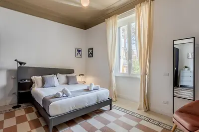 a bedroom with a large bed and a mirror at Flowers Apartment - grande casa a Montesacro in Rome