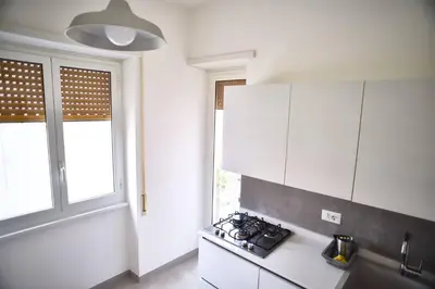 a white kitchen with a stove and a window at L'Oasi di Ale in Rome