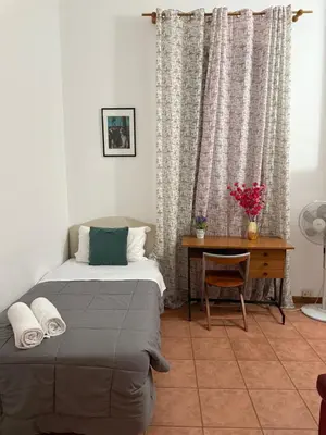 a bedroom with two beds and a ceiling fan at Niam House Volturno in Rome