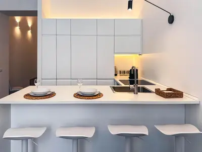 a kitchen with a counter with stools and a sink at Carlo Alberto Suite in Rome