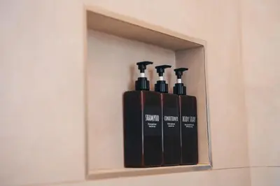 a shelf with three bottles of wine in a wall at Carlo Alberto Suite in Rome