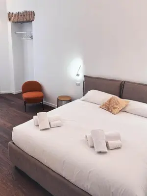 a bedroom with a large white bed with two pillows at Carlo Alberto Suite in Rome