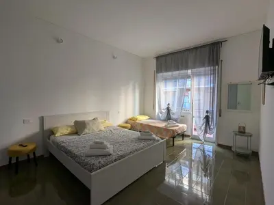 a white bedroom with a bed and a window at Isolina 63 in Rome