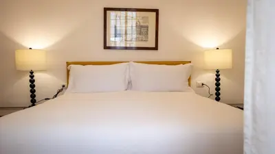 a bedroom with a white bed with two lamps at Domus Pietra nel cuore di Roma in Rome
