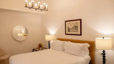 a bedroom with a bed with two lamps and a mirror at Domus Pietra nel cuore di Roma in Rome
