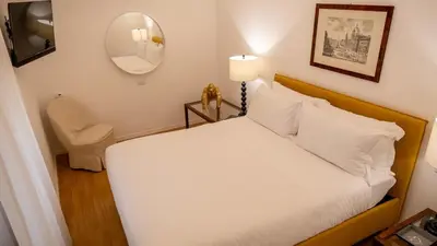 a bedroom with a bed with a mirror and a chair at Domus Pietra nel cuore di Roma in Rome
