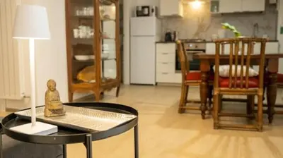a living room with a table and a kitchen at Domus Pietra nel cuore di Roma in Rome