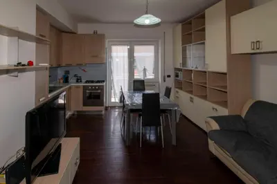 a kitchen and living room with a table and a couch at Apartment Marconi 2833 in Rome