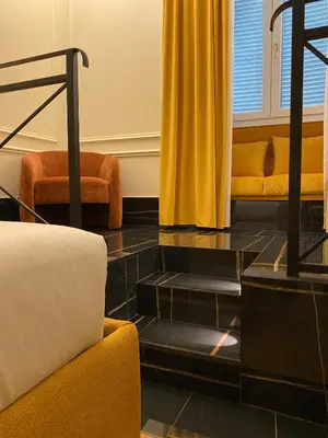 a living room with yellow curtains and black tiled floors at Unicum Trastevere Suites in Rome