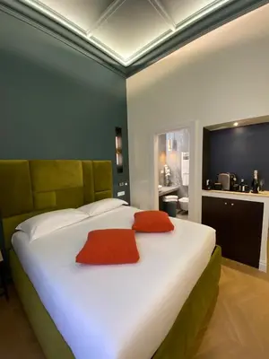 a bedroom with a large white bed with orange pillows at Unicum Trastevere Suites in Rome