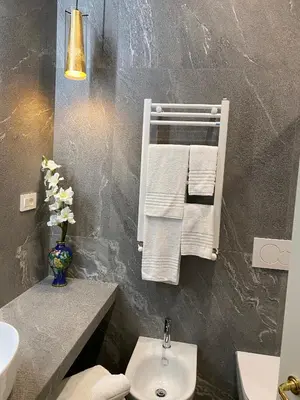 a bathroom with a sink and a toilet and towels at Unicum Trastevere Suites in Rome
