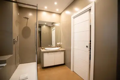 a bathroom with a sink and a glass shower door at Gold Spanish's Steps in Rome