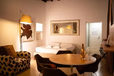 a living room with a bed and a table and a room at Gold Spanish's Steps in Rome