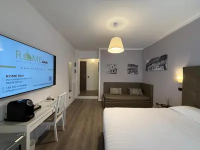 a hotel room with a bed and a flat screen tv at Rome Inn Vatican View Rooms in Rome