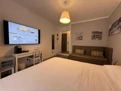 a bedroom with a bed and a flat screen tv at Rome Inn Vatican View Rooms in Rome