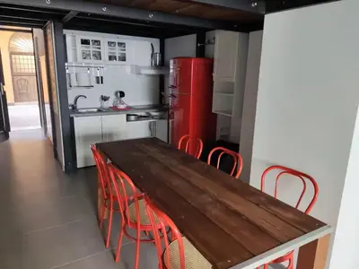 a kitchen with a wooden table and red refrigerator at Termini CARMELOFT in Rome
