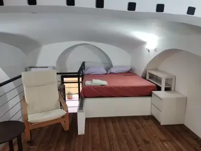 a bedroom with a bed and a chair in a room at Termini CARMELOFT in Rome