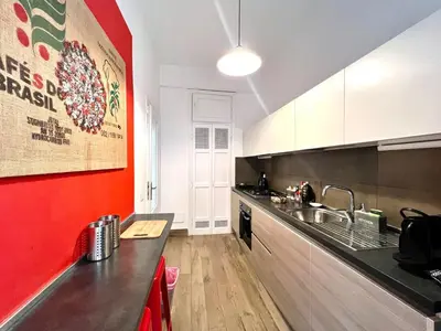 a kitchen with a sink and a red wall at My Roman Home - Prati Vaticano in Rome