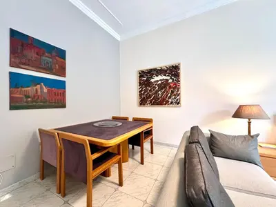 a dining room with a table and a couch at My Roman Home - Prati Vaticano in Rome