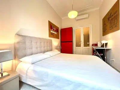 a bedroom with a large white bed and a lamp at My Roman Home - Prati Vaticano in Rome