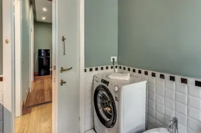 a washing machine in a bathroom next to a door at Corso charming suite in Rome