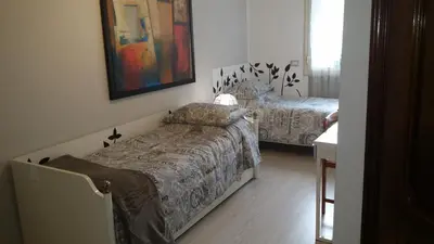 a bedroom with two beds and a table and a mirror at B&B La Perla di Roma in Rome