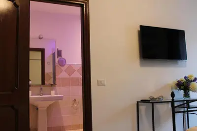 a bathroom with a sink and a television on the wall at B&B La Perla di Roma in Rome