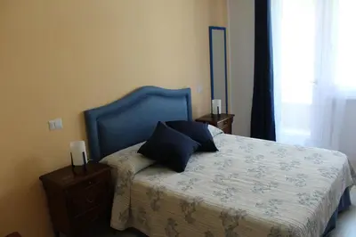 a bedroom with a bed with a blue head board at B&B La Perla di Roma in Rome