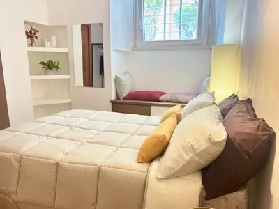a large white bed with pillows on top of it at Saint John House in Rome