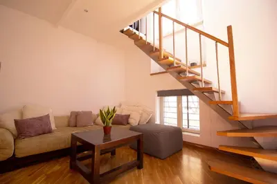 a living room with a couch and a staircase at Saint John House in Rome