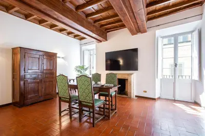 a dining room with a table and chairs and a television at Barchetta Loft in Rome