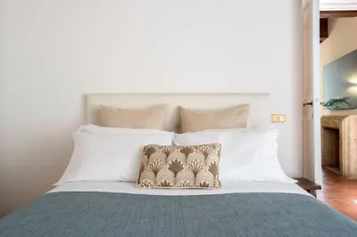 a bedroom with a large bed with white pillows at Barchetta Loft in Rome