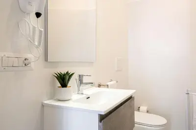 a white bathroom with a sink and a toilet at Barchetta Loft in Rome
