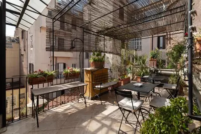 an outdoor patio with tables and chairs and plants at White Room with bathroom and Shared Terrace in Rome