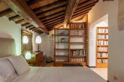 a bedroom with a bed and bookshelves at White Room with bathroom and Shared Terrace in Rome