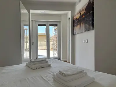 a white bedroom with three towels on a bed at Last floor Aurelio Vaticano in Rome