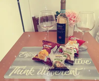 a table with a bottle of wine and some food and wine glasses at casetta romana in Rome