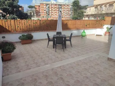 a patio with a table and chairs and a fence at casetta romana in Rome