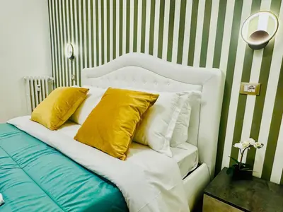 a white bed with yellow pillows on top of it at Rome Termini Down-town Accommodation in Rome