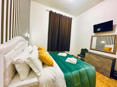 a bedroom with a bed with yellow and white pillows at Rome Termini Down-town Accommodation in Rome
