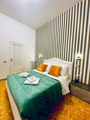 a bedroom with a large green bed with towels on it at Rome Termini Down-town Accommodation in Rome