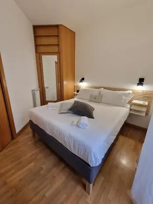 a bedroom with a large bed with white sheets at Casa Claudia in Rome