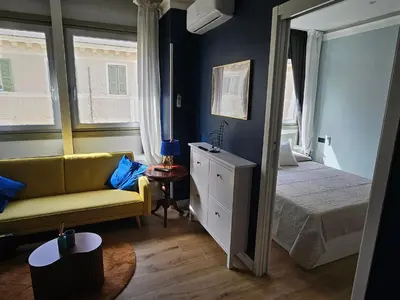a bedroom with a yellow couch and a bed and window at Merulanasuite Saint John in Rome