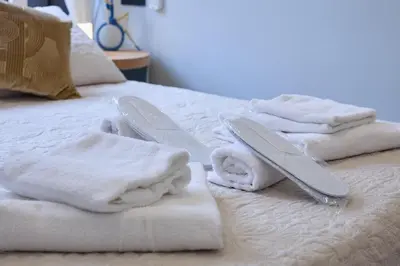 a bed with white towels and tongs on it at Merulanasuite Saint John in Rome