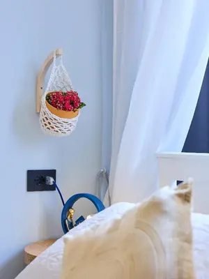 a bedroom with a basket of flowers on the wall at Merulanasuite Saint John in Rome