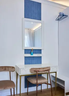 a dressing table with two chairs and a mirror at Merulanasuite Saint John in Rome