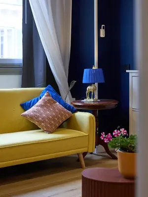a living room with a yellow couch and a table at Merulanasuite Saint John in Rome