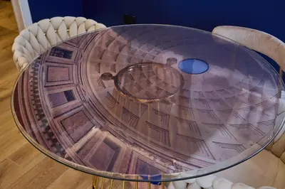 a glass table with chairs around it at Merulanasuite Saint John in Rome