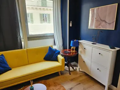 a living room with a yellow couch and a window at Merulanasuite Saint John in Rome