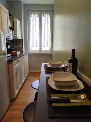 a kitchen with a table with plates and a bottle of wine at Hub in R'home in Rome
